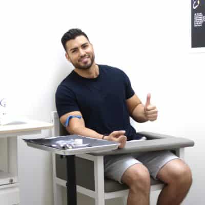 A man sitting in a chair and giving a thumbs up.