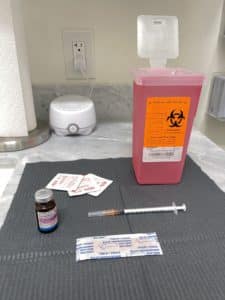 A syringe and a syringe needle are seen positioned on a table, possibly suggesting the utilization of Replacement Therapy.