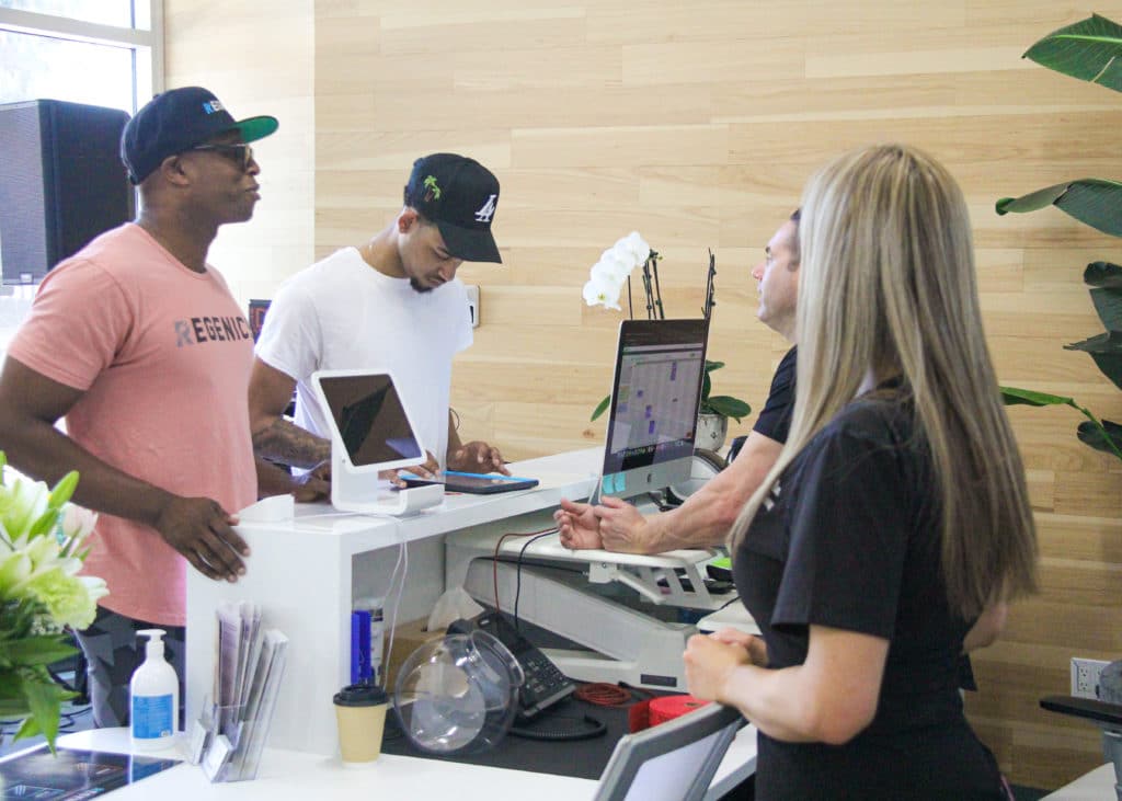 A group of people participating in a Test & Tune UP event, standing in front of a desk.