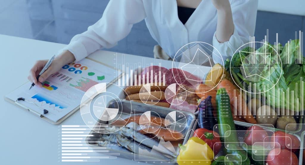 A woman is sitting at a table with a tray full of food, possibly undergoing MICRONUTRIENT TESTING.