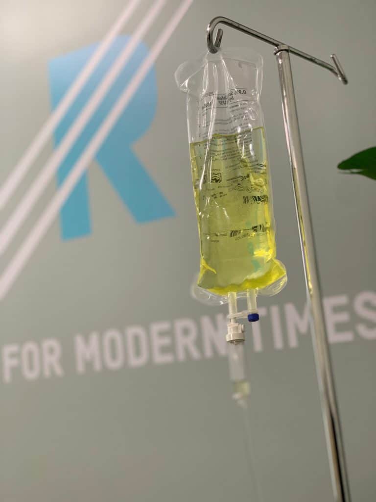 An IV bag with the words "r for modern times" on it, providing health optimization through IV therapy.