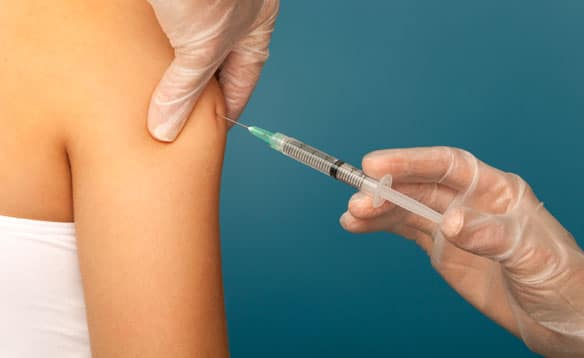 An MIC injection being given to a woman's arm.