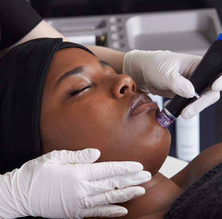 A woman is getting a Hydrafacial treatment on her face.
