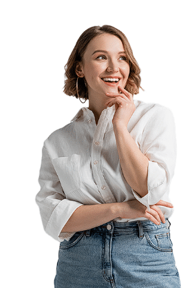 A woman with short hair, wearing a white shirt and blue jeans, smiles while posing with her hand on her chin, as if contemplating the benefits of Tirzepatide medication.