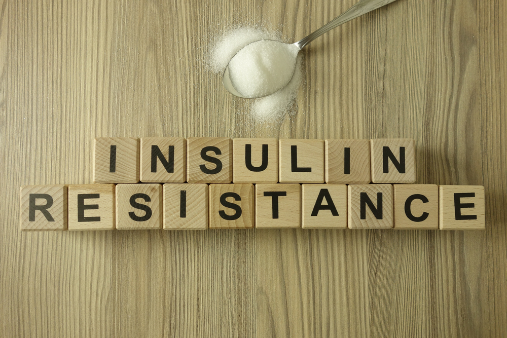 Text insulin resistance from wooden blocks with spoon of sugar, diabetic concept