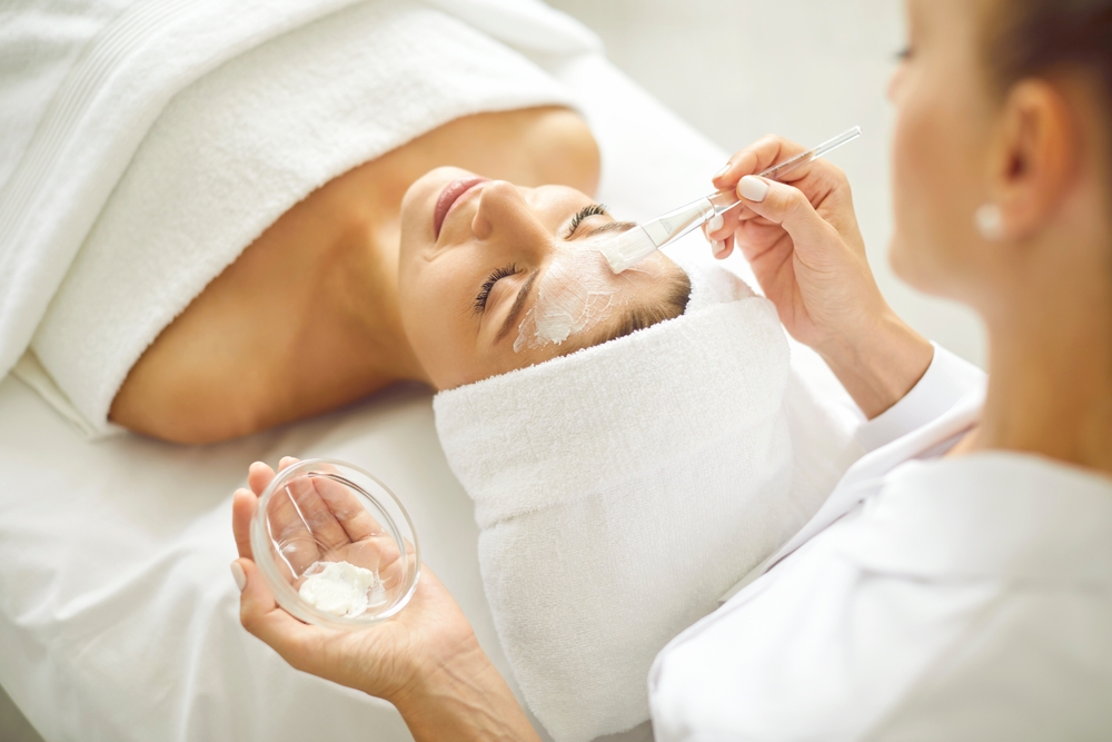 Woman enjoying facial treatment at beauty parlor or spa salon