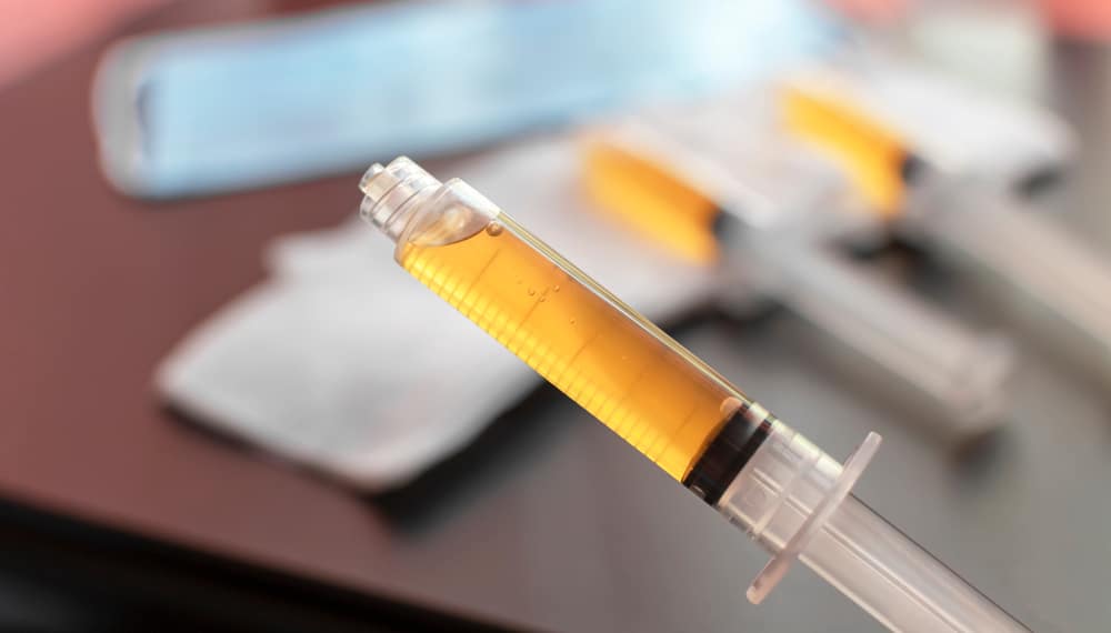 Blood plasma in a syringe on a blurred background. 