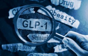 GLP-1 related drugs newspaper headlines with hand and magnifying glass