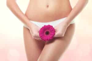 Gynecology concept. Young woman with flower on color background