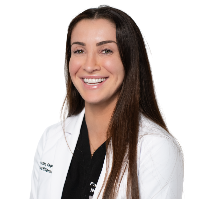 A woman with long brown hair wearing a white lab coat and black top smiles against a plain white background.